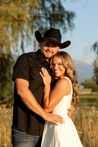 Rilee and Colby hugging and smiling at the camera during their Charlo Montana engagement session with Mission Mountain views