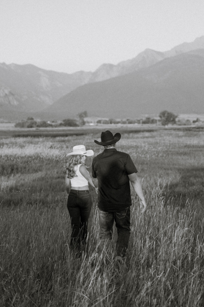 Rilee looking back at Colby while they hold hands walking away during their Mission Mountains engagement session