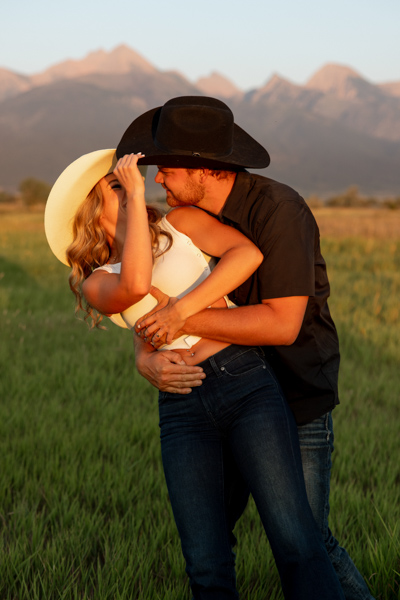 Colby hugging Rilee from behind as she smiles back playfully during their Charlo Montana engagement session