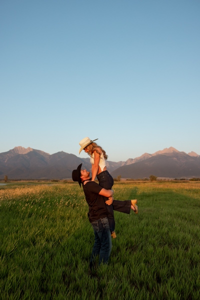Colby lifting Rilee while she looks down at him during their Mission Valley engagement session