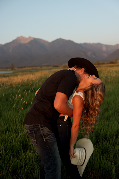 Colby kissing Rilee on the neck as she laughs during their Charlo Montana engagement session