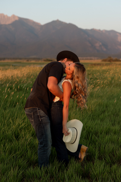 Colby kissing Rilee on the neck while she laughs during their Charlo Montana engagement session