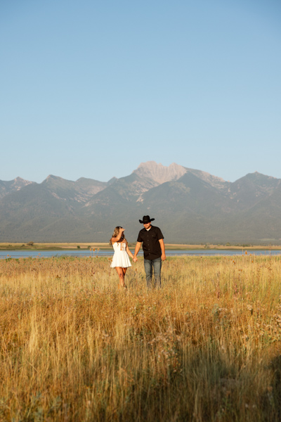 Rilee and Colby holding hands. in a wide shot during their Mission Valley session in Montana