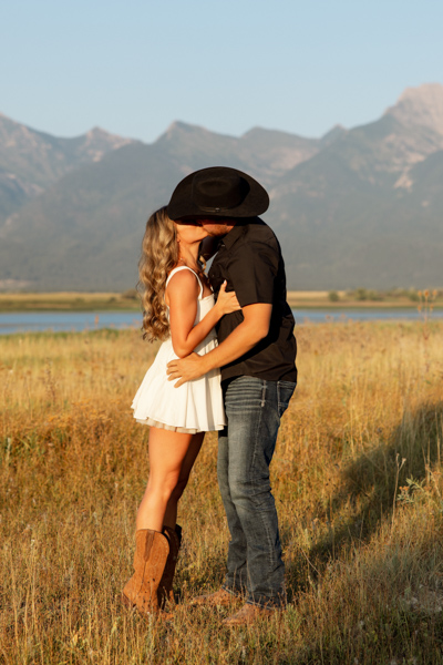 Rilee on tiptoes kissing Colby during their Charlo Montana engagement session with Mission Mountain views