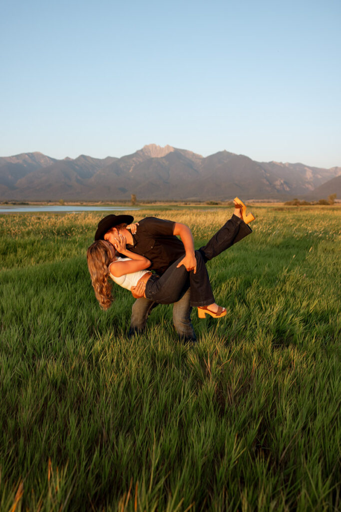 Colby dips Rilee during their Charlo Montana engagement session with Mission Mountain views