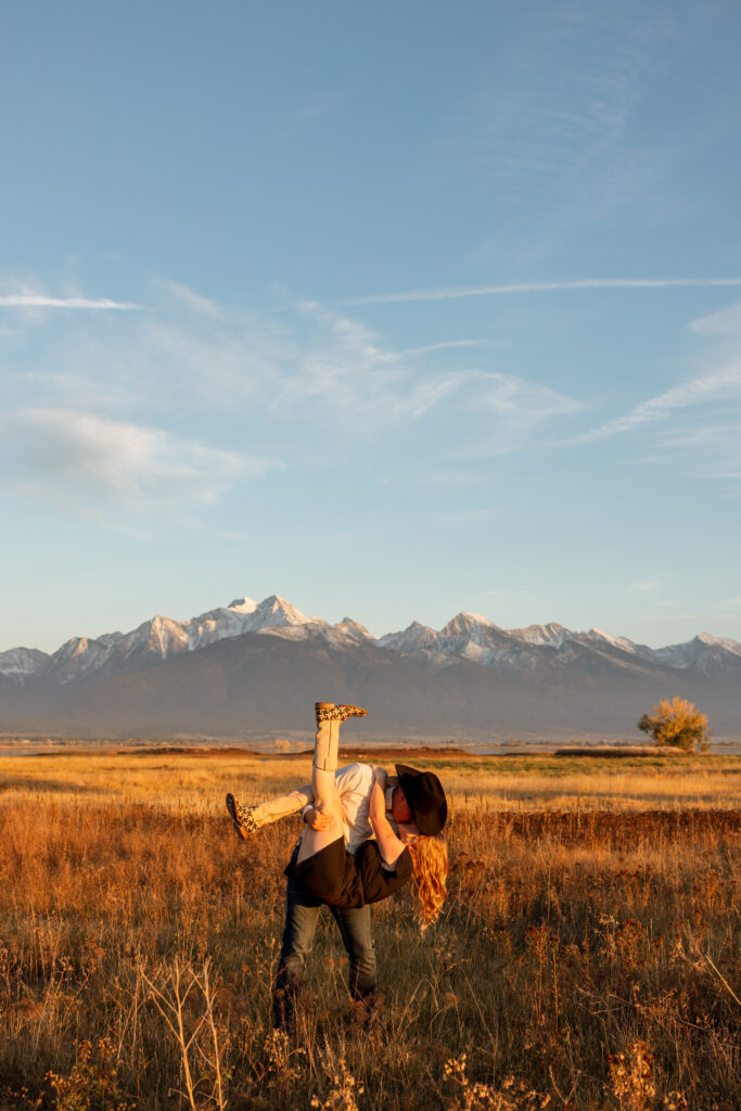 wide shot of couple during golden hour with mission mountain views
