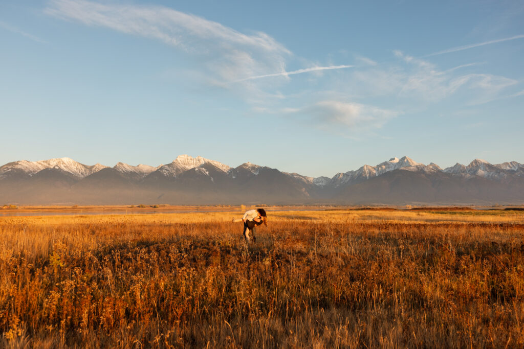 wide shot of couple kissing with mission mountain views