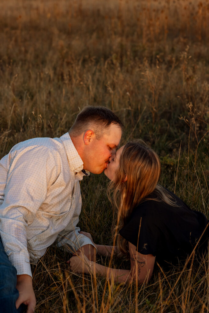 couple laying on the ground kissing during a montana engagement session