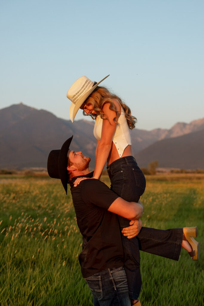 guy lifting girl during mission valley engagement session at sunset