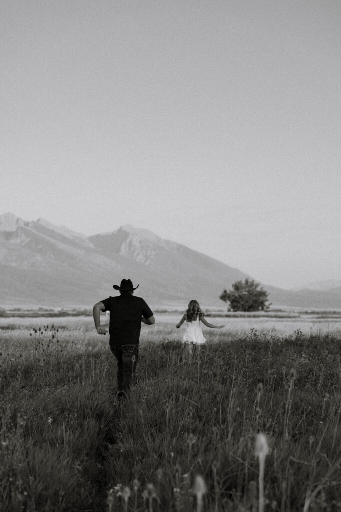 couple chasing each other during an engagement session near ronan montana