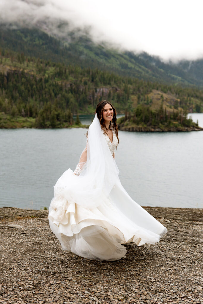 Bride spinning in wedding dress at sunpoint in glacier national park