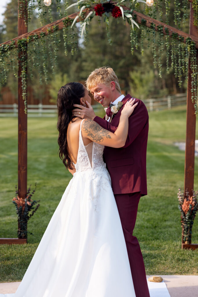 bride and groom smiling at each other seconds before their first kiss as husband and wife