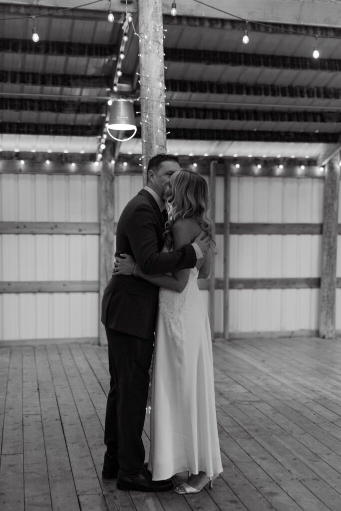 Black and white of groom kissing bride on the cheek at Diamond B Weddings — Kalispell Montana wedding photographer — Stacy Edwards Photography