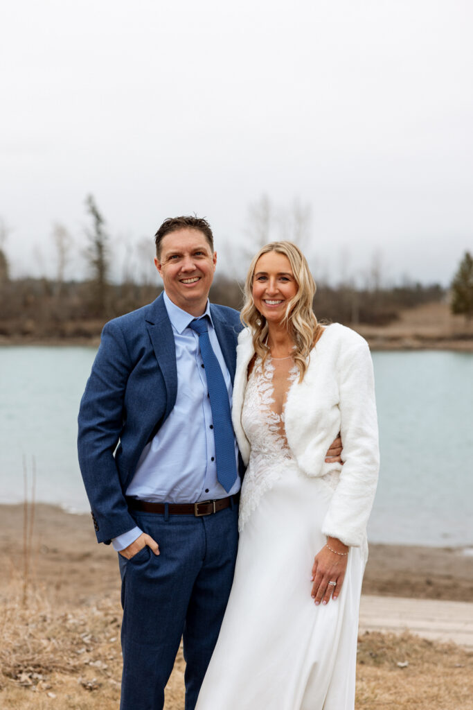 Bride and groom smiling at camera during portraits by the river at Diamond B Weddings — Kalispell Montana wedding photographer — Stacy Edwards Photography