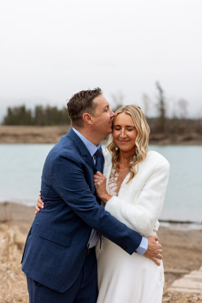 Groom kissing bride on the forehead while she closes her eyes at Diamond B Weddings — Kalispell Montana wedding photographer — Stacy Edwards Photography