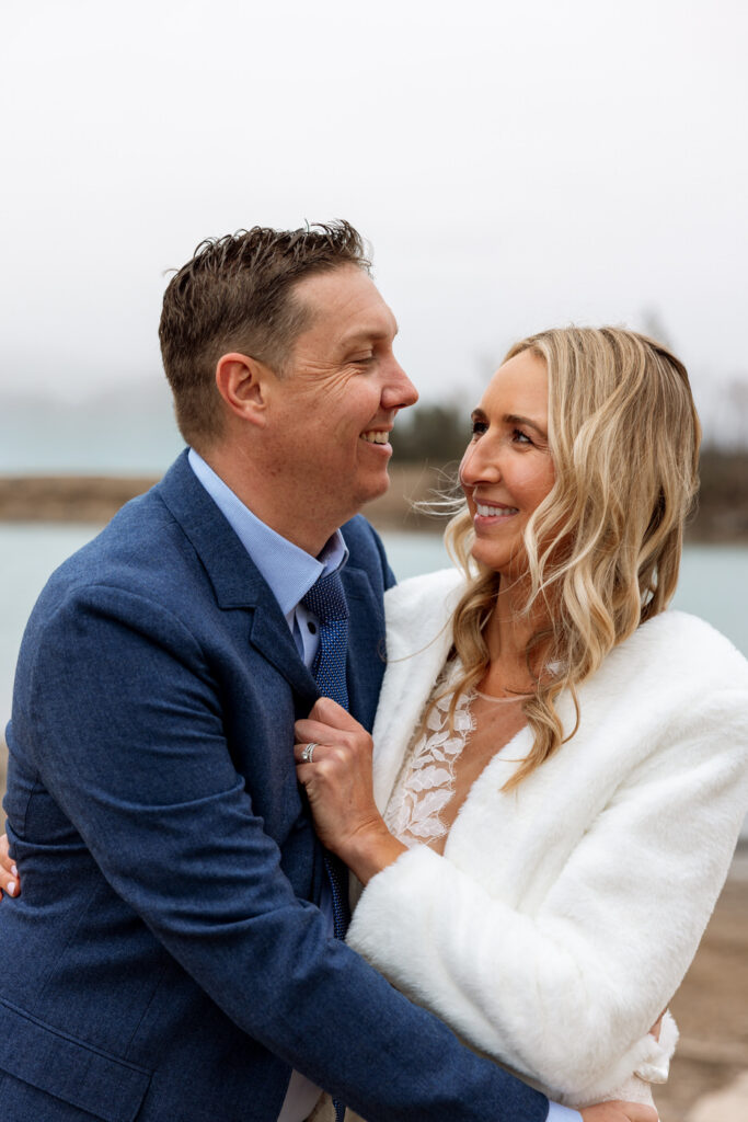 Bride and groom smiling at each other during portraits by the river at Diamond B Weddings — Kalispell Montana wedding photographer — Stacy Edwards Photography