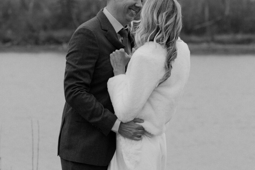 Black and white close up of bride and groom holding each other with groom smiling at Diamond B Weddings — Kalispell Montana wedding photographer — Stacy Edwards Photography