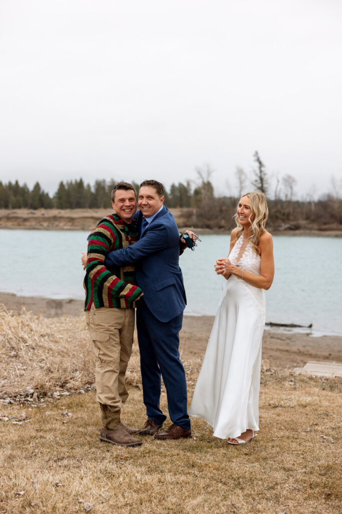 Groom hugging venue owner while bride smiles beside them at Diamond B Weddings — Kalispell Montana wedding photographer — Stacy Edwards Photography