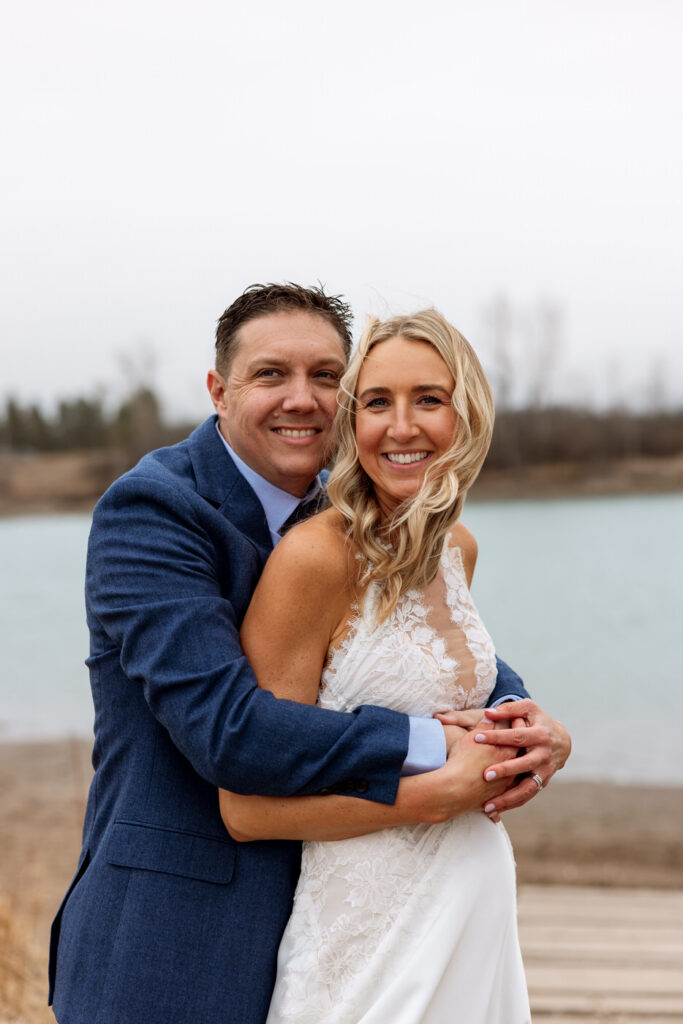 Groom hugging bride from behind smiling at camera at Diamond B Weddings — Kalispell Montana wedding photographer — Stacy Edwards Photography