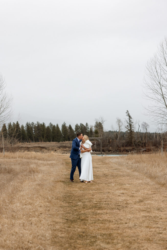 Bride and groom walking side by side arms wrapped around each other leaning in for a kiss at Diamond B Weddings — Kalispell Montana wedding photographer — Stacy Edwards Photography