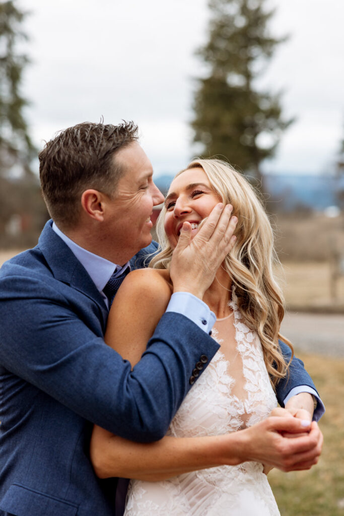 Groom hugging bride from behind turning her face toward him softly laughing together at Diamond B Weddings — Kalispell Montana wedding photographer — Stacy Edwards Photography