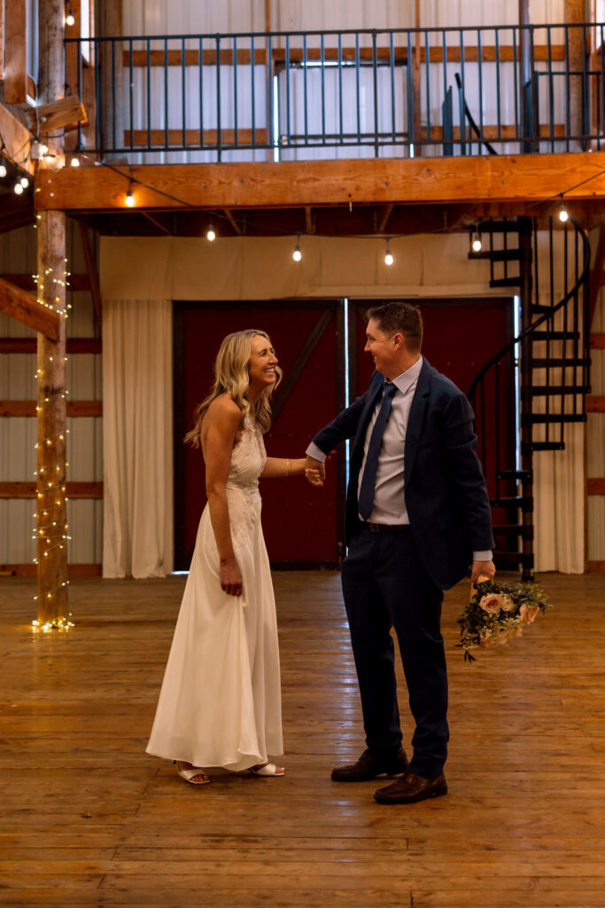 Bride and groom holding hands smiling and laughing at each other at Diamond B Weddings — Kalispell Montana wedding photographer — Stacy Edwards Photography