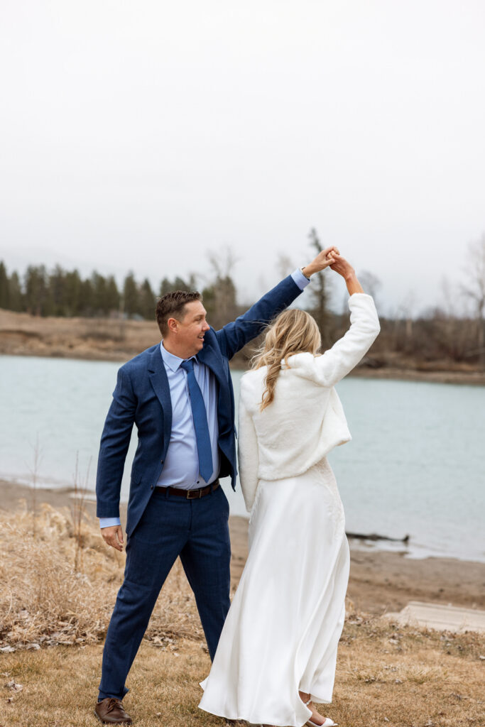 Groom twirling bride during portraits by the river at Diamond B Weddings — Kalispell Montana wedding photographer — Stacy Edwards Photography