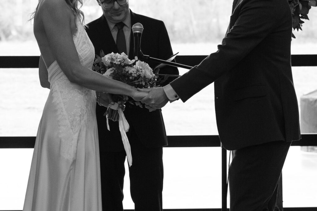 Black and white close up of bride and groom holding hands at the altar at Diamond B Weddings — Kalispell Montana wedding photographer — Stacy Edwards Photography