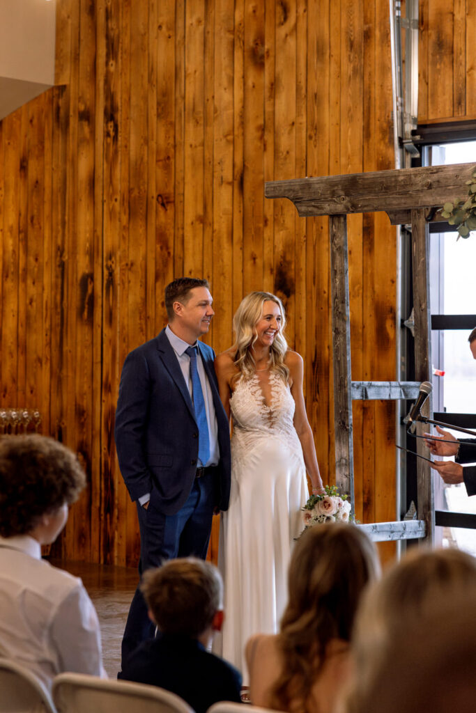 Bride and groom smiling at officiant from alternate angle during ceremony at Diamond B Weddings — Kalispell Montana wedding photographer — Stacy Edwards Photography