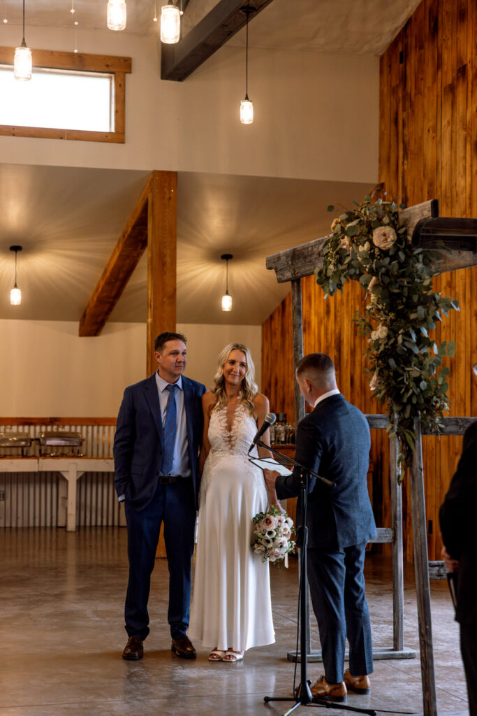 Bride and groom softly smiling at officiant during ceremony at Diamond B Weddings — Kalispell Montana wedding photographer — Stacy Edwards Photography