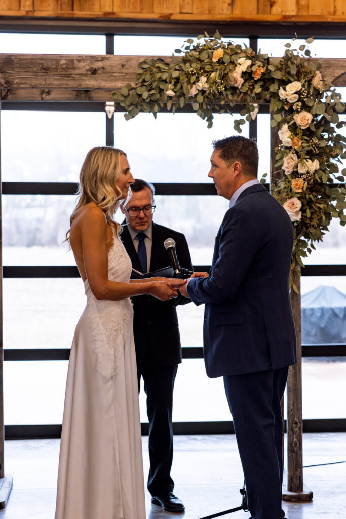 Groom placing wedding ring on bride's finger at Diamond B Weddings — Kalispell Montana wedding photographer — Stacy Edwards Photography