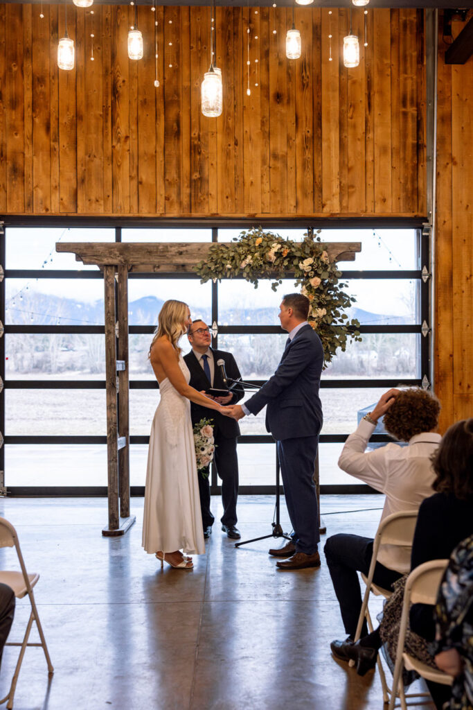 Bride and groom holding hands facing each other during wedding ceremony — Scott and Molly — Diamond B Weddings Kalispell Montana — Stacy Edwards Photography