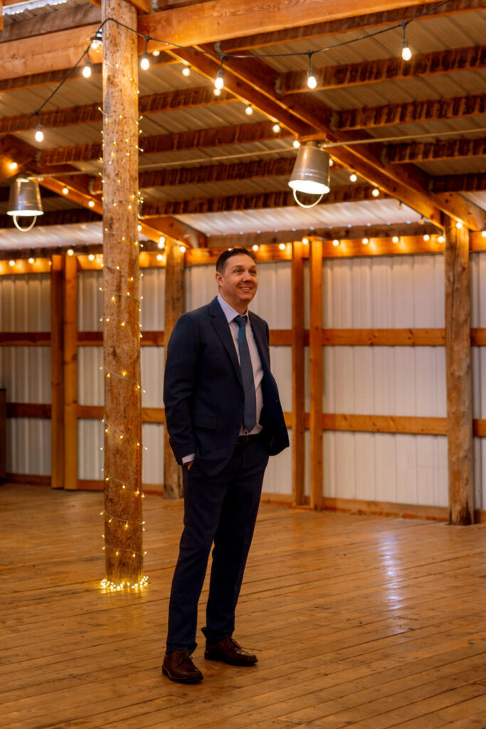 Groom waiting inside twinkle light venue for first look smiling at Diamond B Weddings — Kalispell Montana wedding photographer — Stacy Edwards Photography