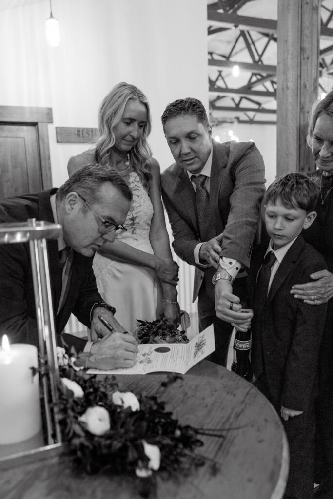 Black and white of officiant signing marriage license with bride and groom — Scott and Molly — Diamond B Weddings Kalispell Montana — Stacy Edwards Photography