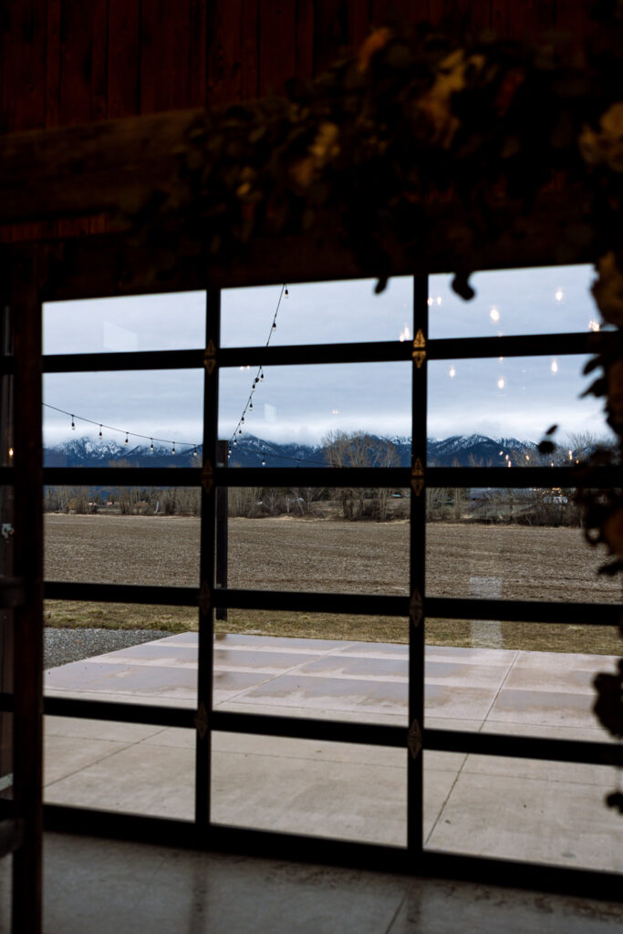 Montana mountains photographed through venue windows during wedding — Diamond B Weddings Kalispell Montana — Stacy Edwards Photography