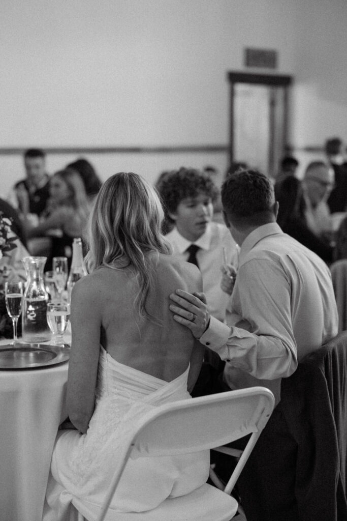 Black and white candid of bride and groom at dinner looking away — Scott and Molly — Diamond B Weddings Kalispell Montana — Stacy Edwards Photography