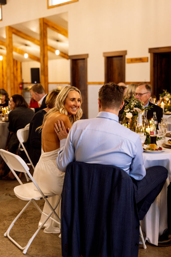 Bride and groom sharing a quiet moment at dinner, groom's hand on bride's shoulder — Scott and Molly — Diamond B Weddings Kalispell Montana — Stacy Edwards Photography