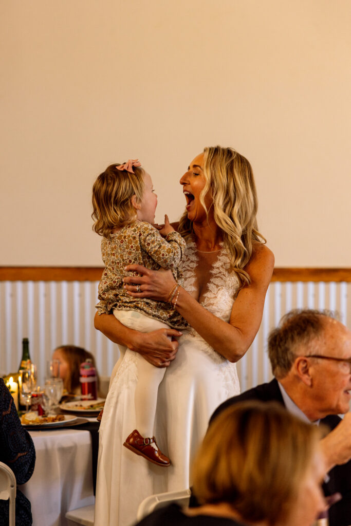 Bride laughing and making faces with a baby during wedding reception — Scott and Molly — Diamond B Weddings Kalispell Montana — Stacy Edwards Photography