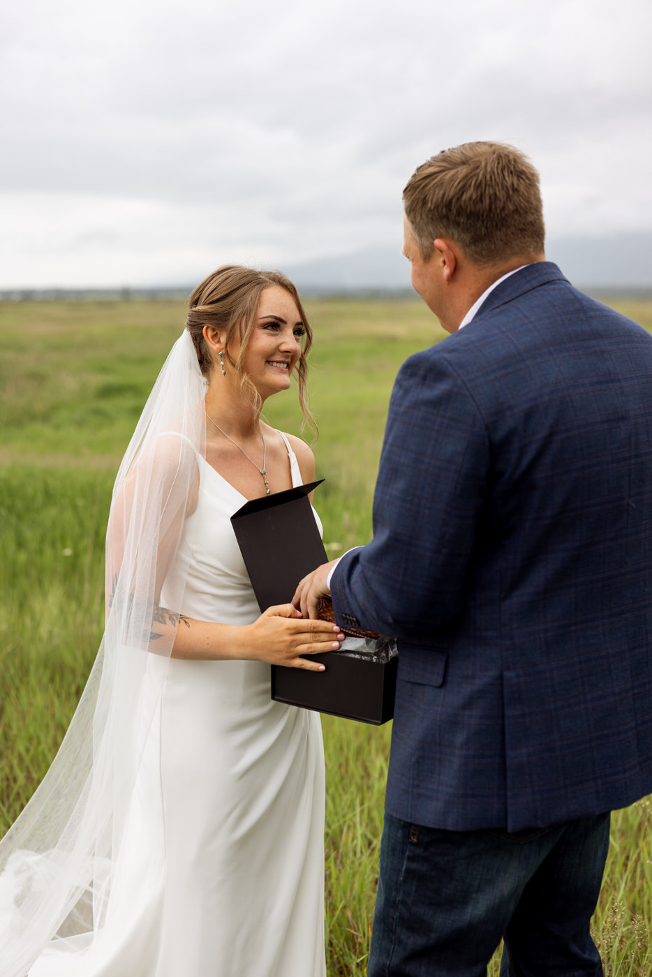 Bride smiling at groom after giving him his wedding gift — Aislynn + Kyle — Mission Valley Wedding — Charlo Montana — Stacy Edwards Photography