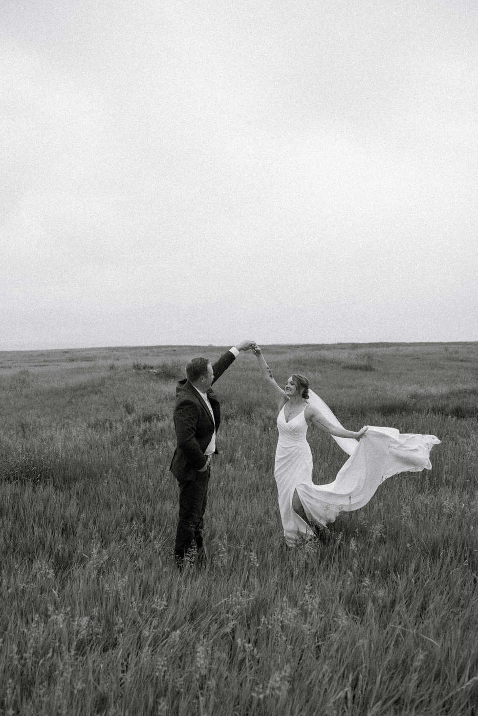 black and white photo of groom twirling bride — Aislynn + Kyle — Mission Valley Wedding — Charlo Montana — Stacy Edwards Photography