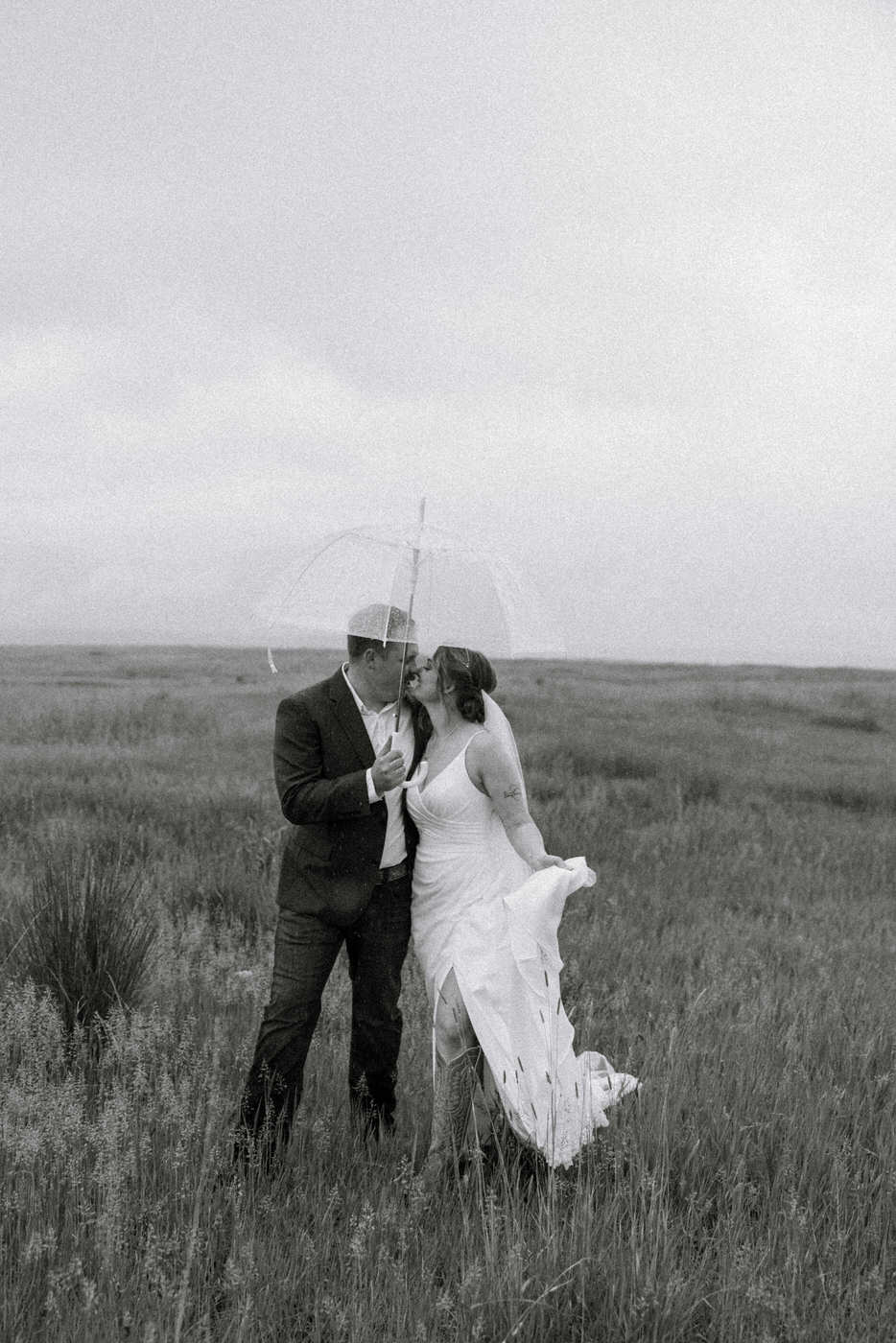 Black and white photo of bride and groom kissing under an umbrella — Aislynn + Kyle — Mission Valley Wedding — Charlo Montana — Stacy Edwards Photography