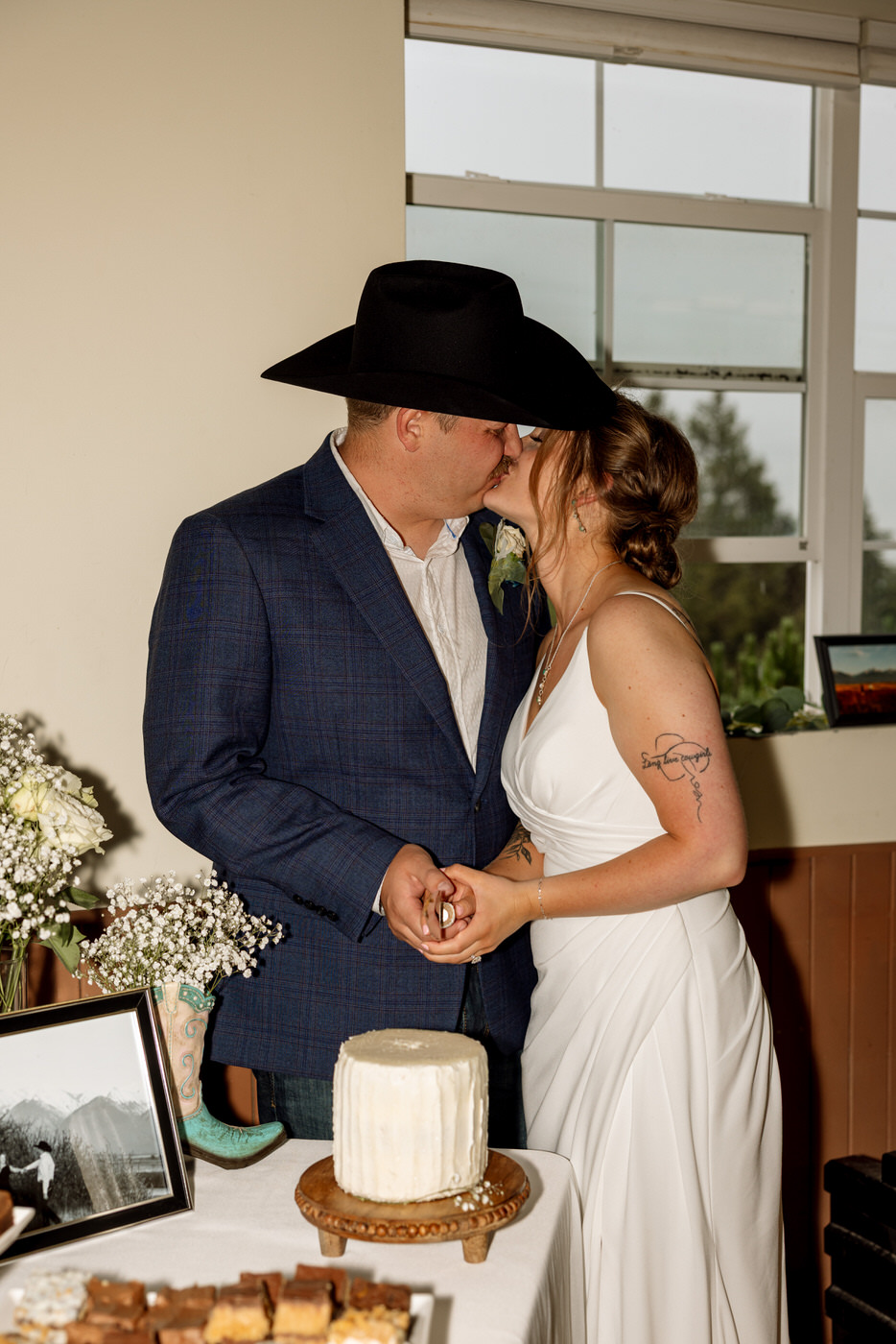 Bride and groom kissing before cutting the wedding cake — Aislynn + Kyle — Mission Valley Wedding — Charlo Montana — Stacy Edwards Photography