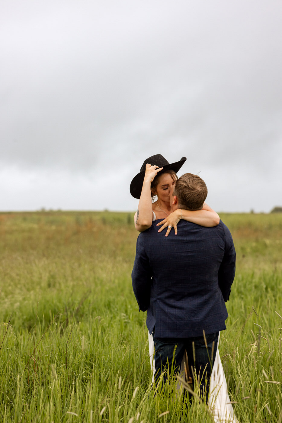 Groom lifting and kissing bride in a grassy field — Aislynn + Kyle — Mission Valley Wedding — Charlo Montana — Stacy Edwards Photography
