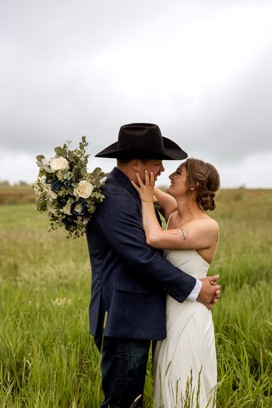 Bride and groom wrapped in a romantic embrace, smiling at each other — Aislynn + Kyle — Mission Valley Wedding — Charlo Montana — Stacy Edwards Photography