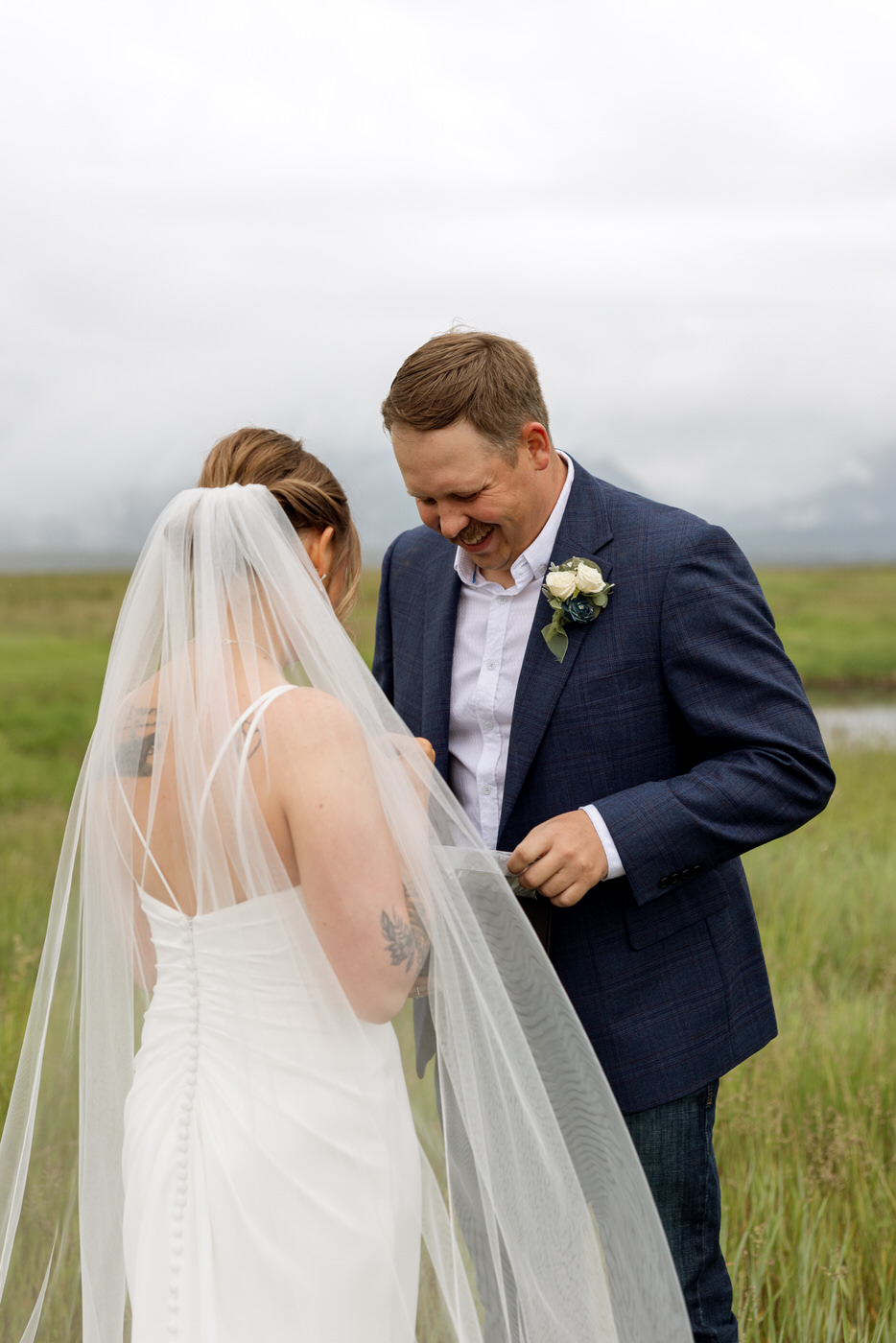 Groom smiling down at wedding gift from bride — Aislynn + Kyle — Mission Valley Wedding — Charlo Montana — Stacy Edwards Photography