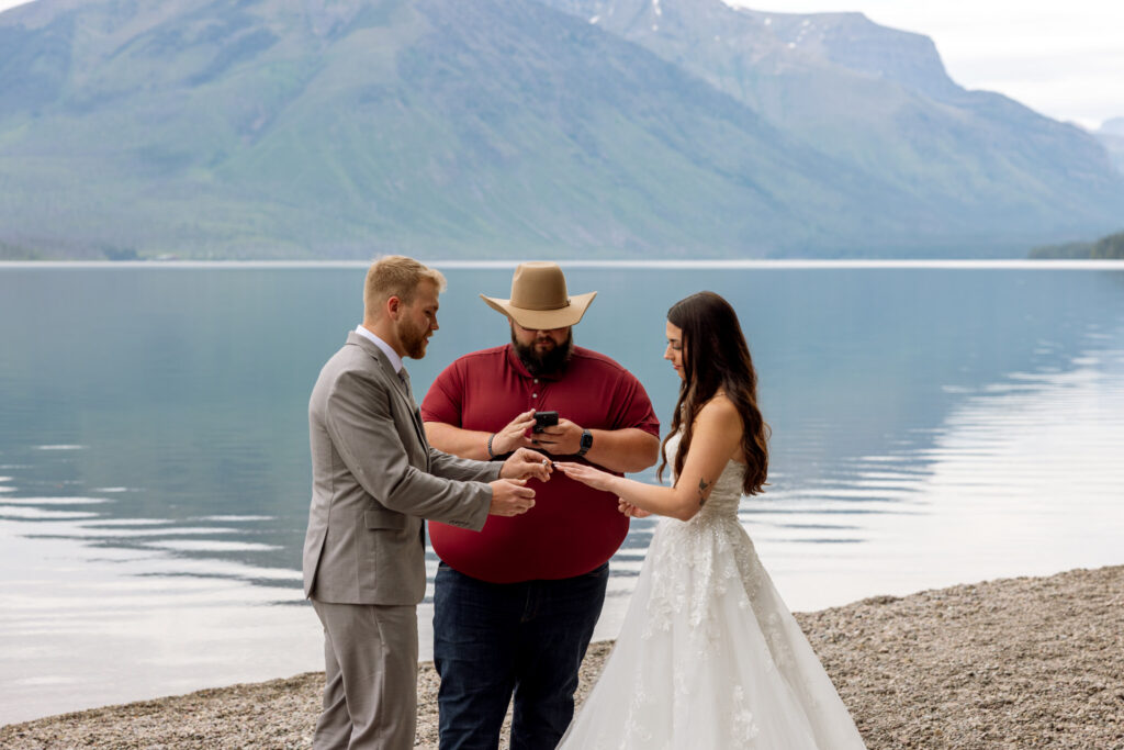Groom placing ring on bride's finger during elopement ceremony at Jackson Bay on Lake McDonald — Glacier National Park elopement — Stacy Edwards Photography