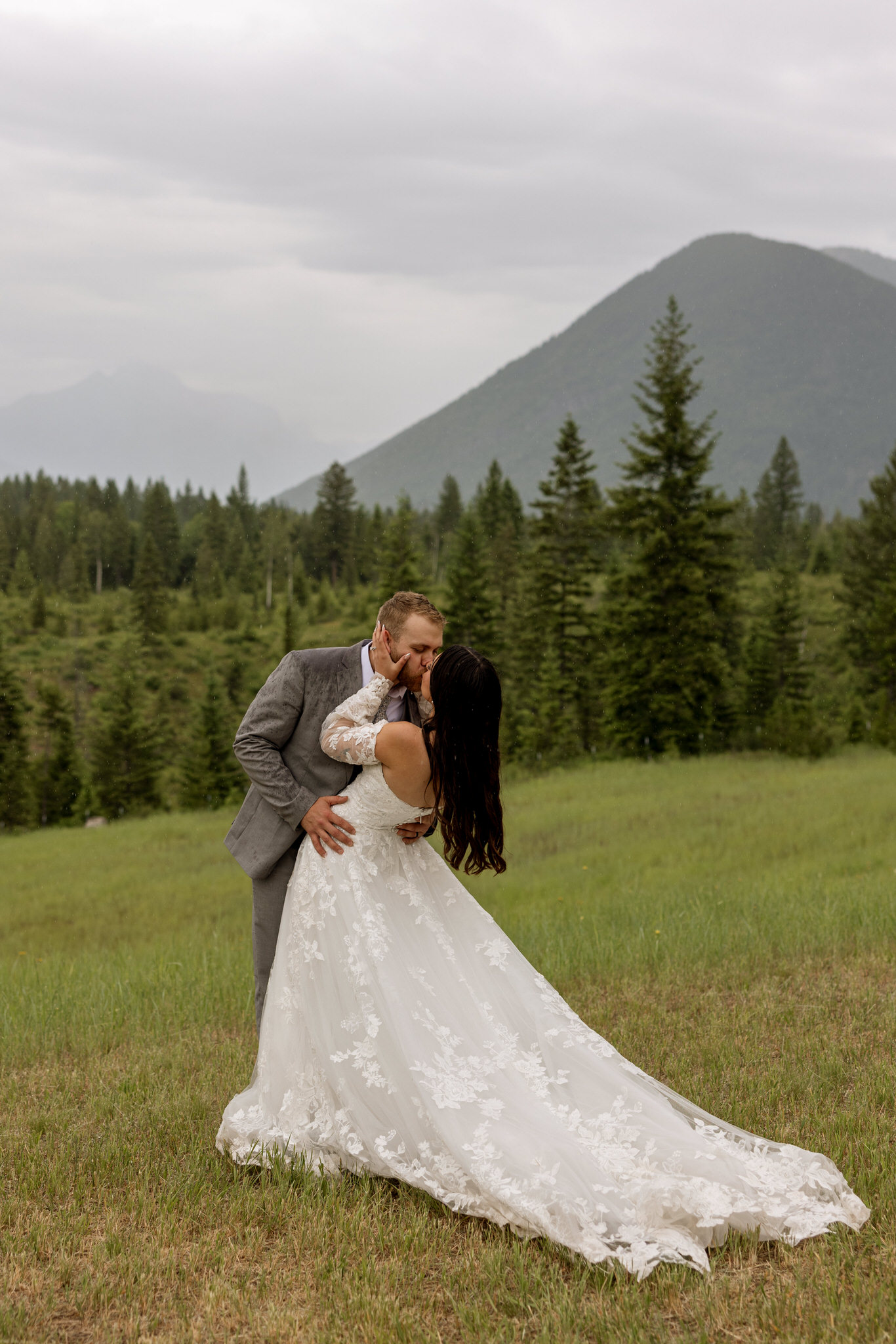 Groom dipping bride in a mountain meadow near West Glacier Montana — Glacier National Park elopement photographer Stacy Edwards Photography