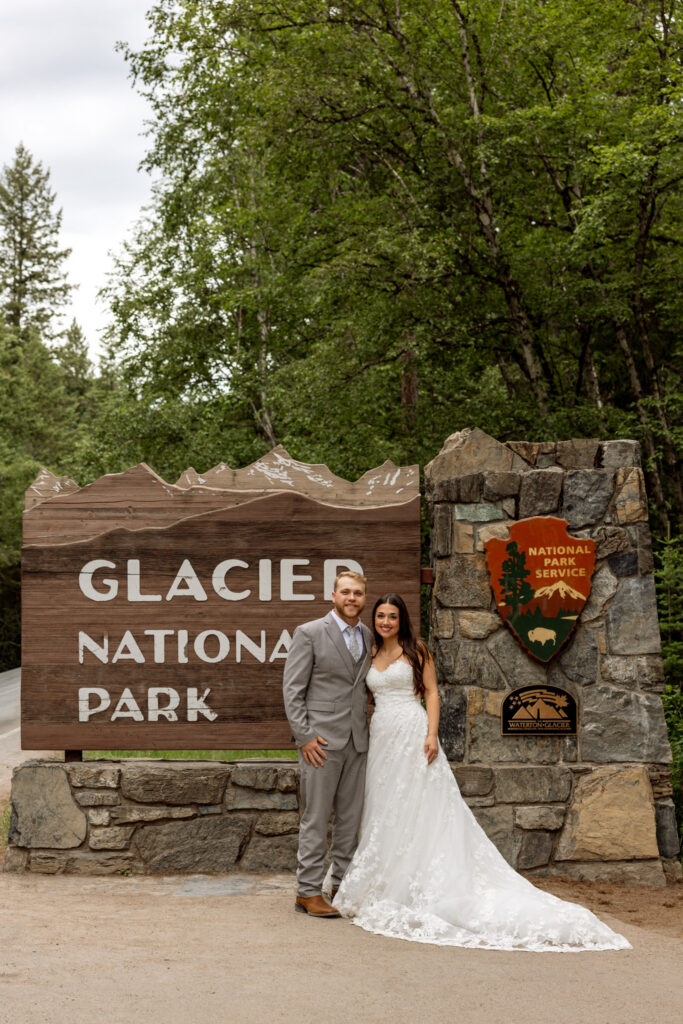 Bride and groom at the Glacier National Park entrance sign after their elopement — Glacier National Park elopement photographer Stacy Edwards Photography