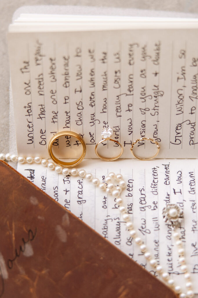 Wedding rings resting on handwritten vow books with pearl necklace — wedding day coverage — Montana wedding photographer Stacy Edwards Photography
