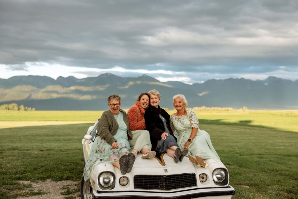 Four grandmothers of bride and groom sitting on the hood of the Camaro — Ember & Altar Wedding — Polson Montana — Stacy Edwards Photography